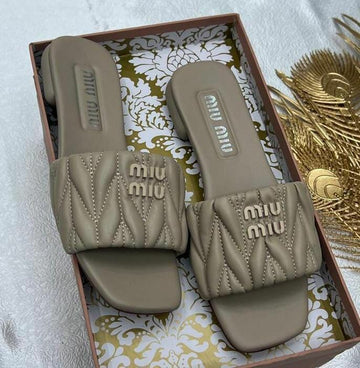 Miu Miu Matelassé Nappa Leather Slides in a caramel or sand-beige colorway