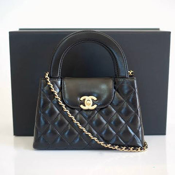 Chanel Kelly Shopping Bag (often called the Chanel Nano or Mini Kelly Shopper) in black quilted leather with a silver-tone CC turn-lock closure.
